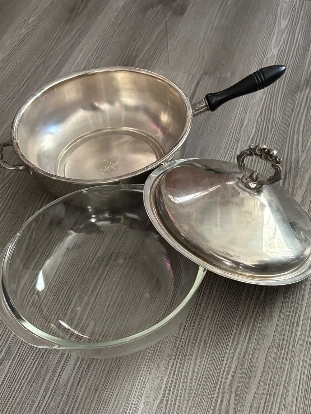 Pyrex glass insert inside a covered silver-plated pot with lid. Used